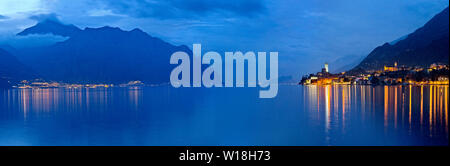 Le lac de garde dans la soirée : sur la droite les lumières de Limone et sur la gauche de la ville de Malcesine avec le château médiéval. Veneto, Italie. Banque D'Images