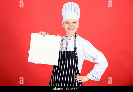 Woman in hat cook et tablier. chef professionnel en cuisine. Cuisine. menu du restaurant. Suivre un régime culinaire. happy woman la cuisson des aliments sains par recette. Femme au foyer avec livre de cuisine saine. L'alimentation biologique. Banque D'Images