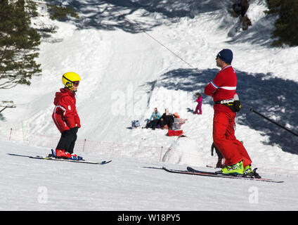 Les Pyrénées centrales à Pont Espagne. Jeune garçon l'apprentissage du ski avec l'aide d'un moniteur de ski. Banque D'Images