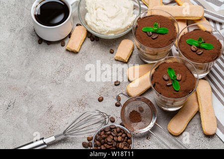 Cadre fait de dessert tiramisu classique dans un verre et les cookies sur fond de béton savoiardi Banque D'Images