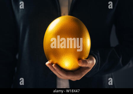La businesswoman holding oeuf d'or comme symbole de l'opportunité d'affaires et le succès Banque D'Images
