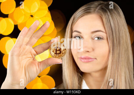 Femme tenant un bitcoin cryptocurrency physique Banque D'Images