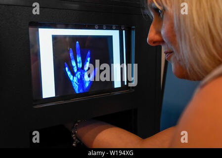 Londres, Royaume-Uni. 1er juillet 2019. Sur le stand de l'Université de Nottingham, une femme regarde la surface de sa main sous la lumière UV révélant les bactéries sur le palm. Aperçu de l'exposition d'été scientifiques annuels à la Royal Society. 22 pièces montrant certaines des plus récentes et les plus novateurs de la recherche en science, ingénierie et technologie de tout le Royaume-Uni est présentée au public du 1er juillet au 7 juillet 2019. Crédit : Stephen Chung / Alamy Live News Banque D'Images