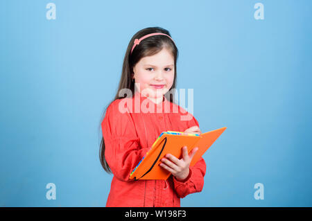 Vous permet de regarder dans le livre de la connaissance scientifique. Adorable petit enfant écrit connaissance rapport d'essai. Adorable petite fille tenant en mains. connaissances livre Jour des connaissances ou le 1 septembre. Banque D'Images