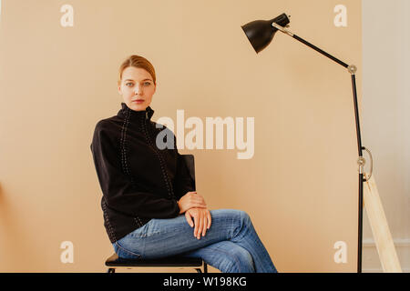 Short-haired woman en fauteuil devant studio light Banque D'Images