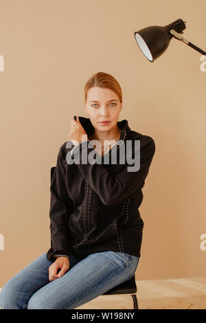 Short-haired woman en fauteuil devant studio light Banque D'Images