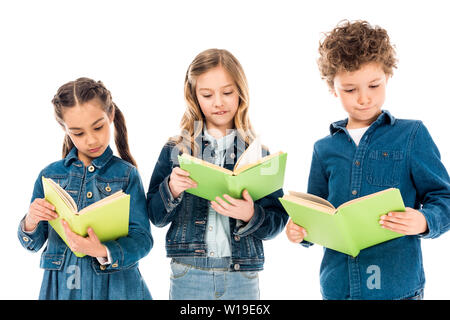 Trois enfants concentré dans la lecture de livres vêtements denim isolated on white Banque D'Images