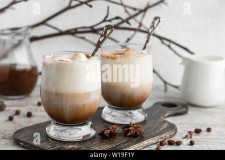 Café glacé avec de la crème de glace à la vanille et cannelle sur un fond clair Banque D'Images