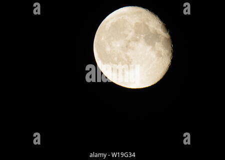 Grande Fraise Juin jaune Lune gibbeuse décroissante, en phase dans le ciel nocturne. Exeter, Devon, UK. Banque D'Images