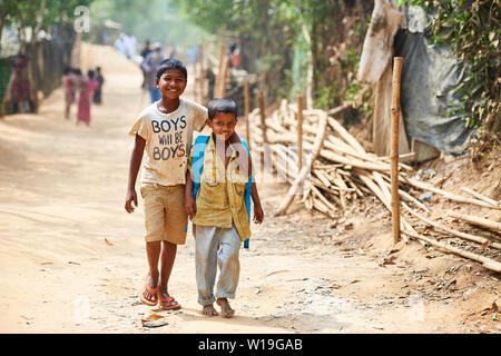 Deux garçons marchant le long d'une rue dans le camp de réfugiés Rohingya de Kutupalong, Bangladesh Banque D'Images