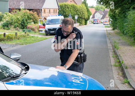 Dehmcurbrock, Allemagne. 1er juillet 2019. Un policier, qui a fermé une route avec sa voiture, regarde une carte. La Bundeswehr a confirmé l'écrasement d'un hélicoptère d'entraînement en Basse-Saxe. L'Eurocopter EC 135 machine a été impliqué dans un accident d'environ 30 kilomètres à l'ouest de Hameln, un porte-parole de l'armée allemande a déclaré à l'agence de presse allemande. Il y avait deux personnes à bord. L'avion appartient à l'International Helicopter Training Centre de Bückeburg. Credit : Stefan Simonsen/dpa/Alamy Live News Banque D'Images