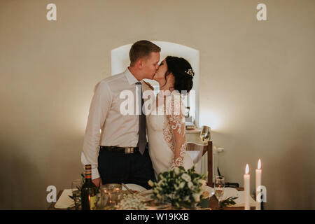 Mariée et le marié s'embrasser le jour de leur mariage. Tout couple marié de aime partager des moments tendres à leur fête de mariage. Banque D'Images