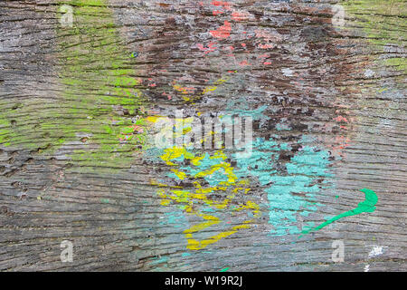 Éclaboussé de peinture aux couleurs vives sur le vieux bois surface Banc Banque D'Images