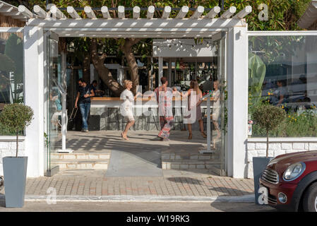 La Canée, Crète, Grèce. Juin 2019. Les clients danser autour du bar d'un restaurant grec dans la région de Chania en Crète. Banque D'Images