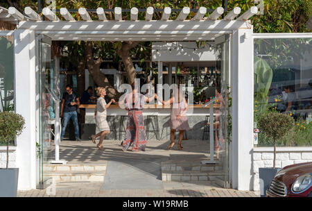 La Canée, Crète, Grèce. Juin 2019. Les clients danser autour du bar d'un restaurant grec dans la région de Chania en Crète. Banque D'Images