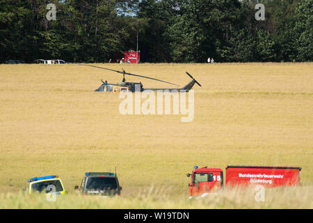 Aerzen, Allemagne. 1er juillet 2019. Les véhicules de secours et un hélicoptère de la Bundeswehr sont près d'un accident sur un champ. La Bundeswehr a confirmé l'écrasement d'un hélicoptère d'entraînement en Basse-Saxe. L'Eurocopter EC 135 machine a été impliqué dans un accident d'environ 30 kilomètres à l'ouest de Hameln, un porte-parole de l'armée allemande a déclaré à l'agence de presse allemande. Il y avait deux personnes à bord. L'avion appartient à l'International Helicopter Training Centre de Bückeburg. Credit : Swen Pförtner/dpa/Alamy Live News Banque D'Images