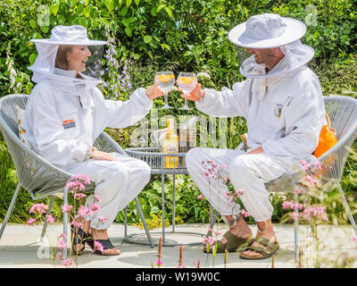 Londres, Royaume-Uni. 1er juillet 2019. Le pollinisateur urbain jardin, jardin de vie -Présenter leur ambition commune pour sauver les pollinisateurs dans tout le Royaume-Uni et mettre un terme à la diminution de leur nombre. onny, Pâques était vêtue de son plein-corps l'apiculture costume avec Warner l'apiculteurs stagiaire de RHS Wisley Garden. Il y avait aussi Warner l G&T sur le jardin à la fois pour l'équipe et tout le plaisir de ses clients. Le Festival des jardins de Hampton Court, 2019. Crédit : Guy Bell/Alamy Live News Banque D'Images