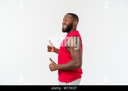 Young african american man sur fond isolé portant sport wear smiling with happy face à avec pouce vers le haut. Banque D'Images