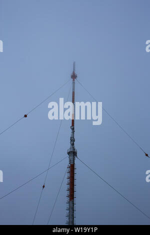 L'antenne radio, rouge et blanc dans des conditions brumeuses Banque D'Images