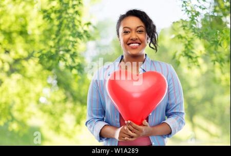 African American Woman with heart-shaped balloon Banque D'Images