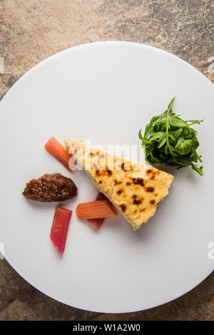 Vue aérienne de savoureux gâteau au fromage cuit au four avec du chutney rhubarbe et rhubarbe marinés Banque D'Images