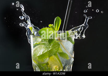 Mojito cocktail ou la limonade avec de la chaux et de menthe en verre sur noir. Close up. Rafraîchissement d'été. Banque D'Images