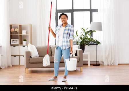 Femme africaine ou ménagère nettoyage planchers à la maison Banque D'Images