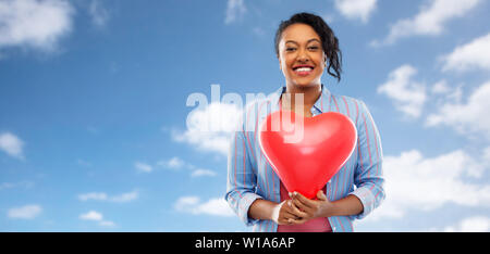 African American Woman with heart-shaped balloon Banque D'Images