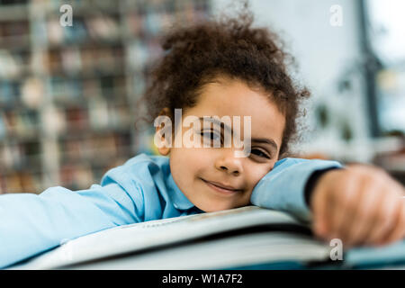 Selective focus of african american kid in situées près de livre sur le tableau Banque D'Images