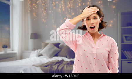 Jeune femme confuse dans la chambre à coucher pendant la nuit pyjama Banque D'Images
