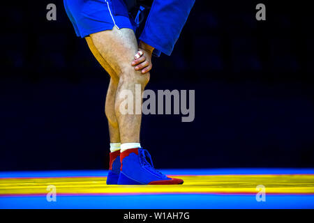 La lutte des hommes sur un tapis de lutte jaune dans la salle de sport Banque D'Images