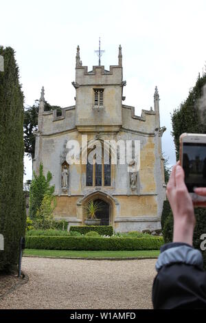 Un touriste prend une photo avec son téléphone de Katherine Parr's chapelle sur le terrain de Château de Sudeley à Winchcombe, Gloucestershire, Royaume-Uni. Banque D'Images