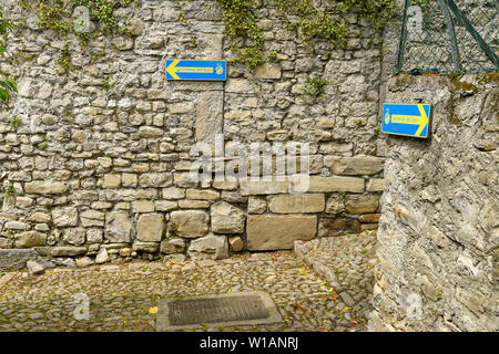 Le lac de Côme, Italie - Juin 2019 : Des signes montrant les marcheurs l'itinéraire sur un sentier de promenade sur le lac de Côme - la Voie verte del Lago di Como. Banque D'Images