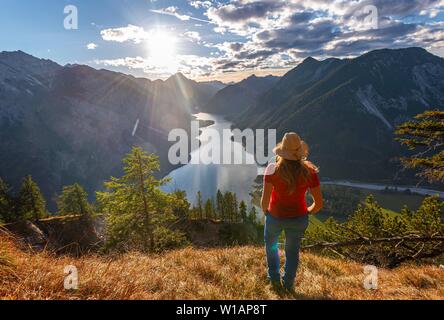 Hker femelle avec un chapeau de soleil à dans la distance, le lac Plansee, Alpes Ammergau, district de Reutte, Tyrol, Autriche Banque D'Images