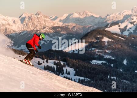 Skieur femelle sur la pente de ski, les montagnes à l'arrière, Skiwelt Wilder Kaiser Brixen im Thale, Tyrol, Autriche Banque D'Images