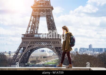 Happy girl sur l'arrière-plan de la Tour Eiffel à Paris. La France dans le monde du tourisme. Banque D'Images