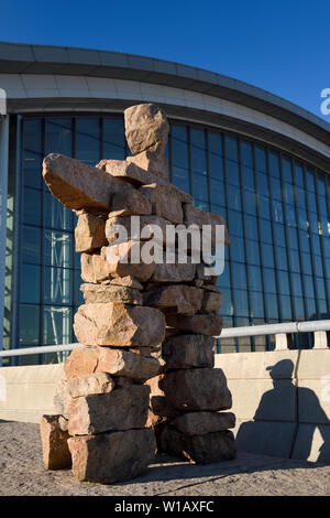 Inuit Inukshuk statue en pierre rouge avec l'ombre de l'homme à l'Aéroport Pearson International Airport Terminal 1 Toronto Canada Dans Morning Sunrise Banque D'Images