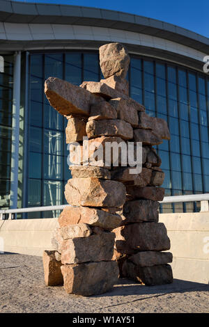 Inuit Inukshuk statue en pierre rouge de l'homme avec les bras levés à l'Aéroport Pearson International Airport Terminal 1 Toronto Canada Dans Morning Sunrise Banque D'Images