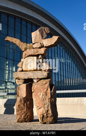 Inukshuk statue en pierre rouge tendre les bras accueillant à l'Aéroport Pearson International Airport Terminal 1 Toronto Canada Dans Morning Sunrise Banque D'Images