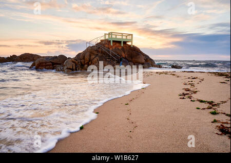 Point de vue ou d'un belvédère sur les rochers sur une plage de Vila do Conde, Portugal, au coucher du soleil. Banque D'Images