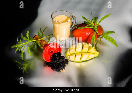 Bol avec du tabac à narguilé dans la fumée. Lassi à la mangue shisha tabac. Banque D'Images