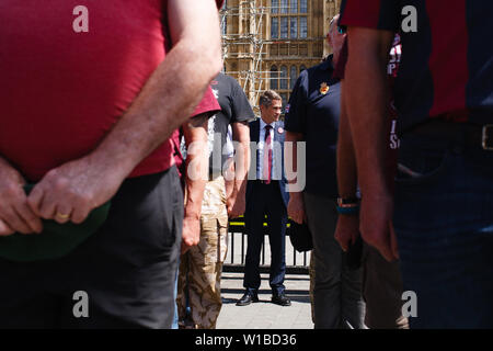 La Grande-Bretagne l'ancien secrétaire d'État à la défense Gavin Williamson observe un silence avec anciens combattants tournent le dos à la Chambre du Parlement au cours d'une protestation contre l'accusation d'anciens soldats britanniques pour les meurtres de guerre. La manifestation centrée sur l'affaire en cours de la encore les "soldat sans nom F', accusé de deux chefs de meurtre au meurtre sur le Dimanche sanglant à Londonderry, en Irlande du Nord, en 1972. Banque D'Images