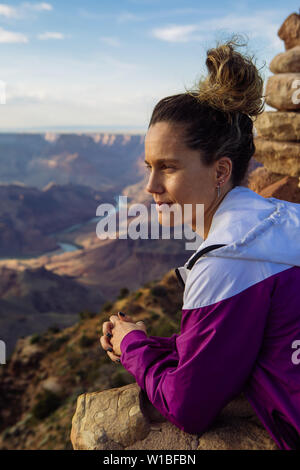 De race blanche, curly haired woman touristiques regardant le coucher du soleil de Desert View, le Parc National du Grand Canyon, Arizona, USA Banque D'Images