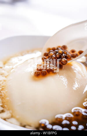 Taiwan - Dessert gastronomique populaire de tapioca pearl ball (la bulle) tofu caillé mixte (pudding, douhua dou hua) en blanc bol, Close up, le mode de vie Banque D'Images