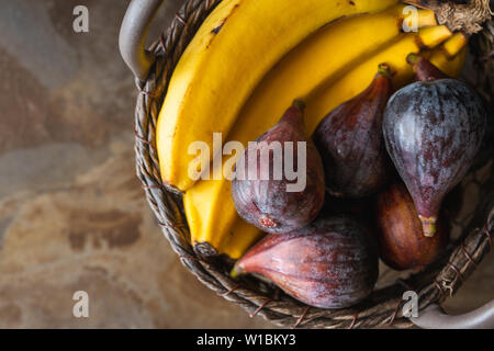 Les bananes et les figues fraîches dans un panier, Close Up, Vue du dessus. Concept Fruits tropicaux Banque D'Images