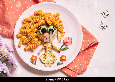 Funny Girl face à la nourriture avec escalope, pâtes et légumes Banque D'Images