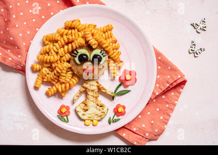 Funny Girl face à la nourriture avec escalope, pâtes et légumes Banque D'Images