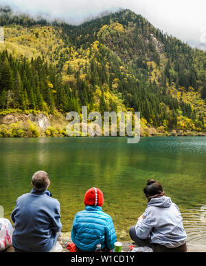 Famille ayant un déjeuner pique-nique à Long Lake à Jiuzhaigou et admirez la vue de l'automne. Banque D'Images