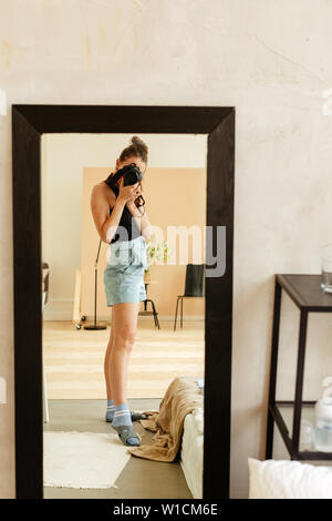 Jeune femme prenant photo dans le miroir Banque D'Images