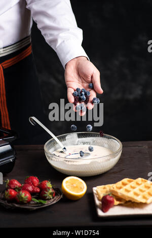 L'ajout de chef des fruits dans la pâte à gaufres close up Banque D'Images